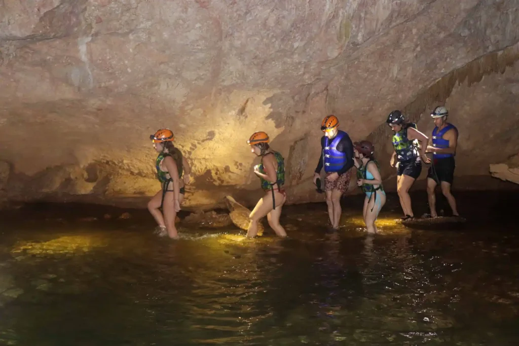 Group-of-guests-exploring-Nohoch-Cheen-Cave-at-Jaguar-Paw-during-Belize-cave-tubing-tour