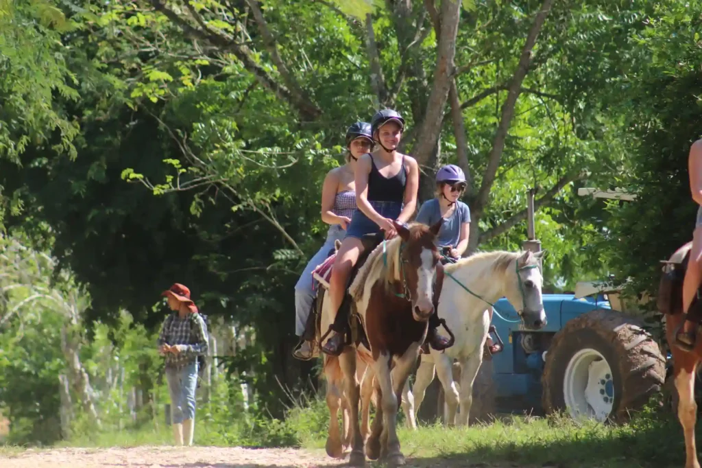 Guests horseback riding on San Lorenzo Farm trails near San Ignacio, Belize